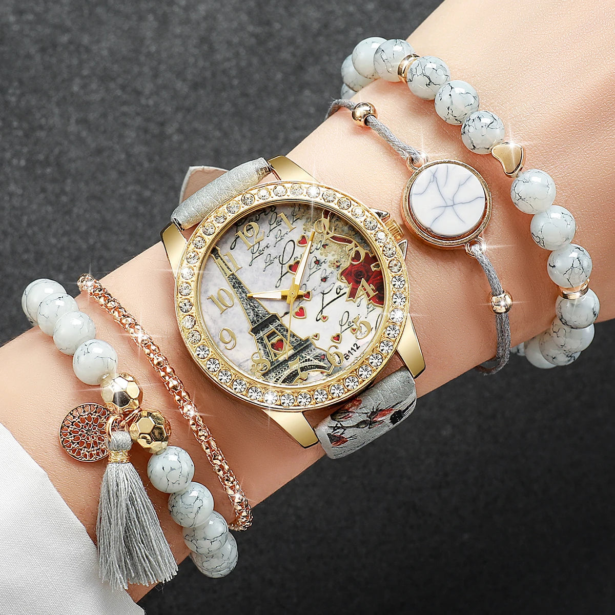 Wrist with a decorative watch and multiple bracelets on a dark background
