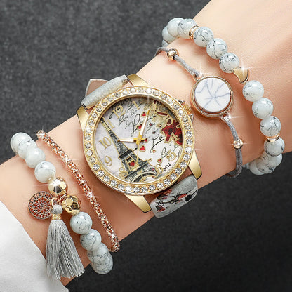 Wrist with a decorative watch and multiple bracelets on a dark background